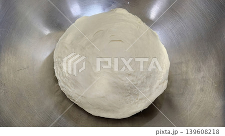 Fresh raw yeast dough ball in a stainless steel mixing bowl ready for proofing and baking Fresh raw yeast dough ball in a stainless steel mixing bowl ready for proofing and baking 139608218
