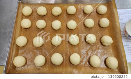 Unbaked Yeast Dough Balls on Baking Tray with Parchment Paper Unbaked Yeast Dough Balls on Baking Tray with Parchment Paper 139608223