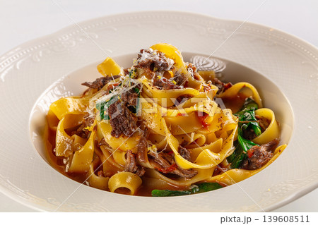 Gourmet fettuccine pasta with beef ragu and spinach, served in an ornate bowl on a white background Gourmet fettuccine pasta with beef ragu and spinach, served in an ornate bowl on a white background 139608511