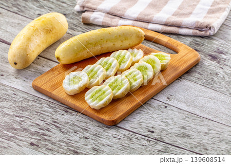 Freshly Sliced Yellow Cucumbers on a Wooden Cutting Board Freshly Sliced Yellow Cucumbers on a Wooden Cutting Board 139608514