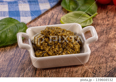Fresh pesto sauce in a white ceramic bowl with basil leaves 139608532