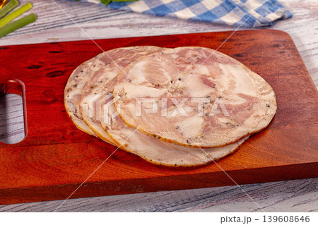 Sliced pork and chicken roll appetizer on wooden cutting board with fresh vegetables Sliced pork and chicken roll appetizer on wooden cutting board with fresh vegetables 139608646