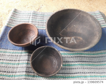Three Different Sizes of Traditional Clay Plates on Plastic Mat Background Three Different Sizes of Traditional Clay Plates on Plastic Mat Background 139609574