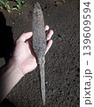A left hand holding an ancient and rusty Javanese spearhead showing pitted metal texture in Indonesia. 139609594