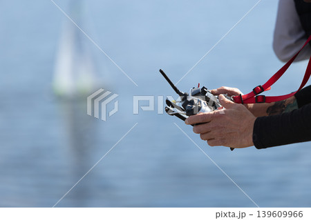 Senior man operating a remote control boat in outdoor setting. Senior man operating a remote control boat in outdoor setting. 139609966