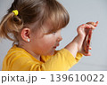Young girl making a photo with her smartphone, exploring digital tools at early age. 139610022