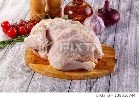 Raw whole chicken over board Raw whole chicken over board 139610744