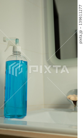Blue cleaning spray bottle on bathroom sink for hygiene and sanitation Blue cleaning spray bottle on bathroom sink for hygiene and sanitation 139611277