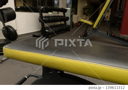 Modern gym interior with weight bench and free weights Modern gym interior with weight bench and free weights 139611312