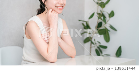 頬杖をつく美肌の笑顔のアジア人女性(美容・エステ・スキンケアイメージ) 頬杖をつく美肌の笑顔のアジア人女性(美容・エステ・スキンケアイメージ) 139611444