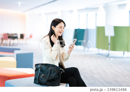 訪問先でスマホを操作する女性 139611486