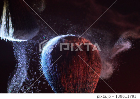 Closeup of soft powder mist on brush in atmospheric setting. Texture analysis of gentle powder mist drifting over makeup tools in studio lighting 139611793