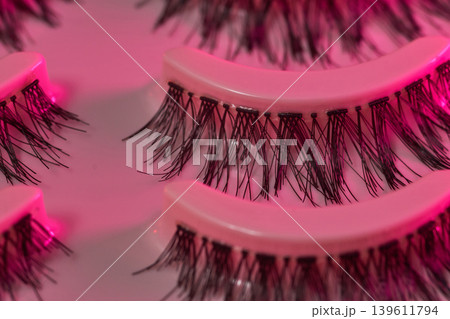 Lash display scene. Eyelash trays under vibrant neon illumination. Luxurious lash presentation using colorful ambient lighting effects 139611794