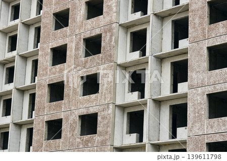 Mid range view raw concrete blocks and empty window voids, modular housing shell under inspection, developer survey Mid range view raw concrete blocks and empty window voids, modular housing shell under inspection, developer survey 139611798
