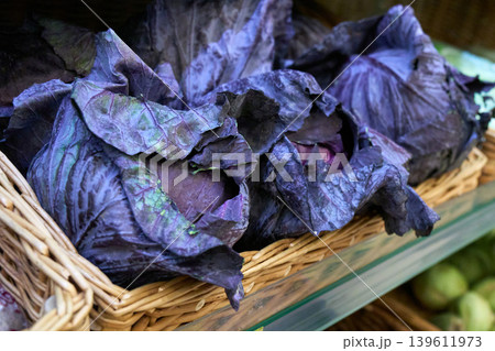 Red cabbage displayed on a shelf in a grocery store during the day for customers to buy Red cabbage displayed on a shelf in a grocery store during the day for customers to buy 139611973
