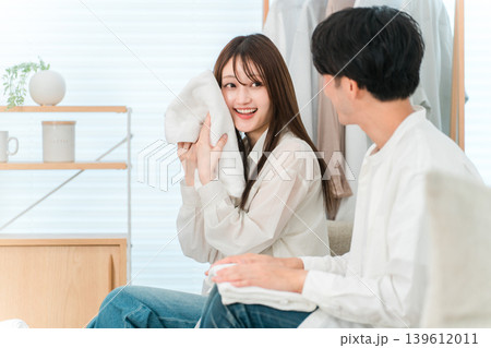 リビングで洗濯物を畳む笑顔の夫婦,カップル（バスタオル,肌触り,仕上がり) 139612011