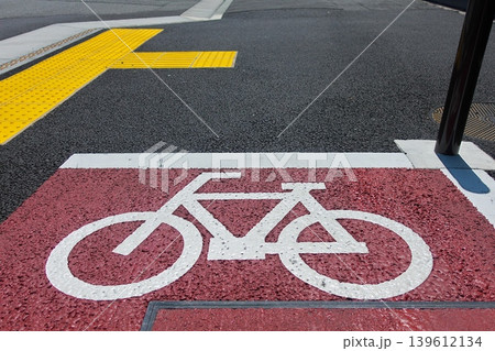 道路に描かれた赤色の自転車専用レーン標示。改正道路交通法による罰則強化と交通安全のイメージ。 道路に描かれた赤色の自転車専用レーン標示。改正道路交通法による罰則強化と交通安全のイメージ。 139612134
