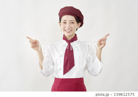 左右を指差すパティシエ女性 139612575