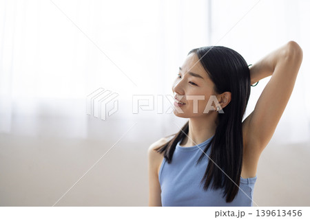 明るい窓辺でリラックスして微笑む日本人のミドル女性 139613456