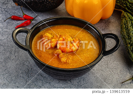 Authentic shrimp curry in a bowl with fresh chili, pepper, and avocado ingredients. 139613559