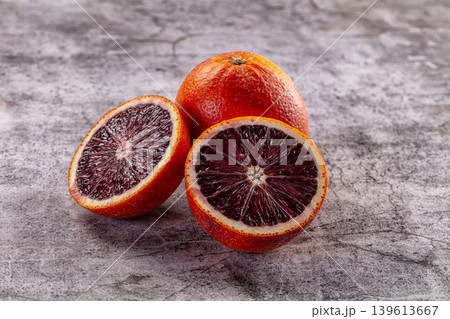 Fresh whole and sliced blood oranges on a grey textured background. Fresh whole and sliced blood oranges on a grey textured background. 139613667