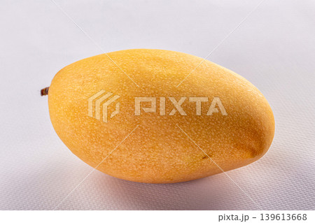 Ripe yellow mango fruit on a clean white textured background. Ripe yellow mango fruit on a clean white textured background. 139613668