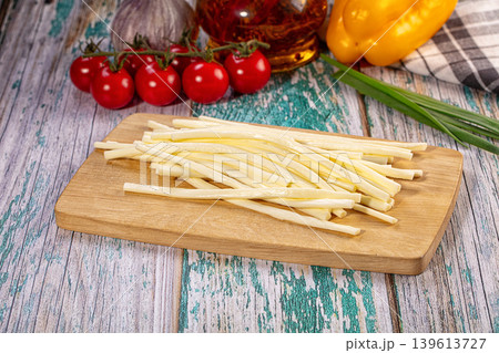 Fresh string cheese appetizer on rustic wood board with tomatoes and scallions 139613727