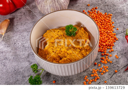 Spicy red lentil dip in bowl with fresh bell pepper garlic and chili on grey background 139613729