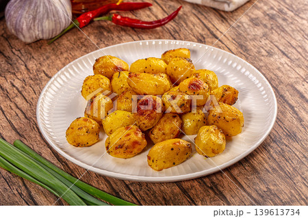 Golden roasted baby potatoes with spices on rustic wooden background Golden roasted baby potatoes with spices on rustic wooden background 139613734