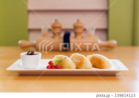 Fried cheese or potato dumplings with berry jam and redcurrant garnish Fried cheese or potato dumplings with berry jam and redcurrant garnish 139614123