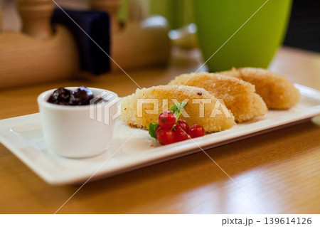 Fried sweet dumplings with berry jam and redcurrant garnish Fried sweet dumplings with berry jam and redcurrant garnish 139614126