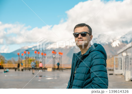 Man in sunglasses at mountain outdoor gym, snowy peaks behind Man in sunglasses at mountain outdoor gym, snowy peaks behind 139614326