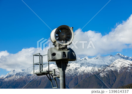 Snowmaking machine at mountain ski resort on sunny day Snowmaking machine at mountain ski resort on sunny day 139614337