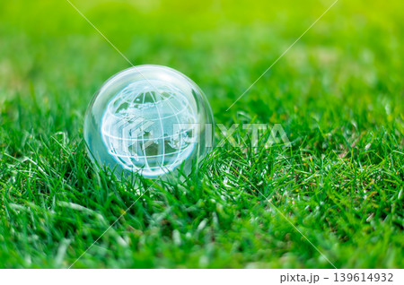 Global Ecology Concept, Glass Earth Sphere on Lush Lawn Representing Clean Energy and Planet Protection Global Ecology Concept, Glass Earth Sphere on Lush Lawn Representing Clean Energy and Planet Protection 139614932