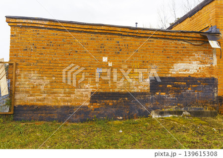 Colorful textured exterior. Building facade with layered repairs and weathered appearance throughout Colorful textured exterior. Building facade with layered repairs and weathered appearance throughout 139615308