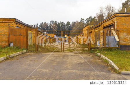 Rundown courtyard enclosed by aged structures. Empty yard encircled by deteriorated sheltering buildings Rundown courtyard enclosed by aged structures. Empty yard encircled by deteriorated sheltering buildings 139615324