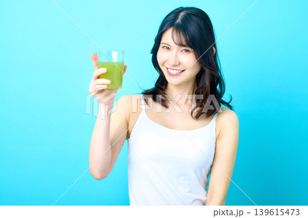 青汁を掲げて笑顔の若い日本人女性 乾杯 青汁を掲げて笑顔の若い日本人女性 乾杯 139615473