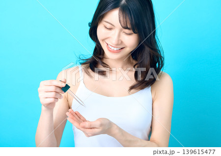 美容液を手に垂らして微笑む若い日本人女性 スキンケア 139615477