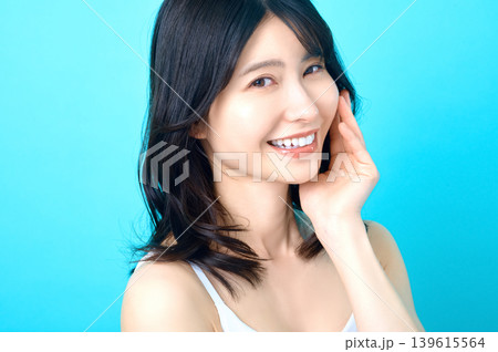 頬に手を当てて微笑む若い日本人女性 美肌イメージ 頬に手を当てて微笑む若い日本人女性 美肌イメージ 139615564