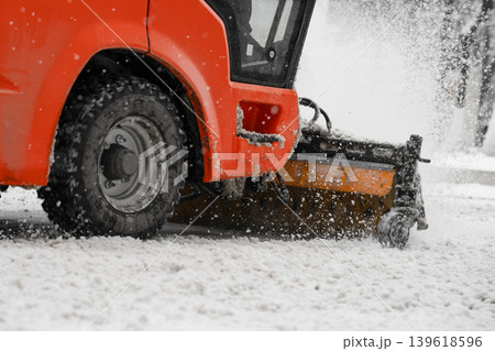 A machine for street clearing snow after a snow storm. Winter road clearing concept . Close up view . A machine for street clearing snow after a snow storm. Winter road clearing concept . Close up view . 139618596