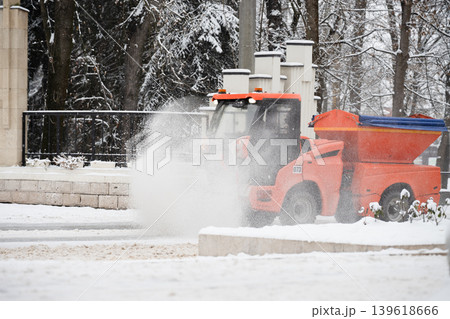 Compact municipal snow sweeper with rotary brush . Snow removal concept . A sweeper moves along a snow-covered street 139618666