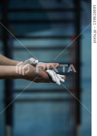 Close-up of hands applying climbing chalk. Magnesium carbonate powder used to improve grip and reduce moisture during indoor rock climbing and bouldering training. 139618695