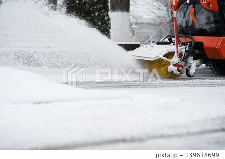 Snowblower machine with rotary brush clears snow . Heavy duty vehicle performs public maintenance Snowblower machine with rotary brush clears snow . Heavy duty vehicle performs public maintenance 139618699