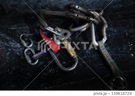 Concept of adventure, sport, and outdoor activity. Metal pitons and carabiners used in rock climbing and mountaineering. 139618729