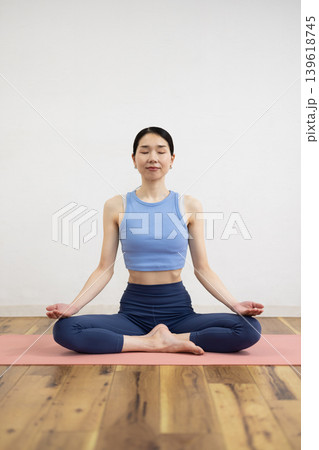 マットの上で瞑想ポーズをとる日本人のミドル女性 139618745