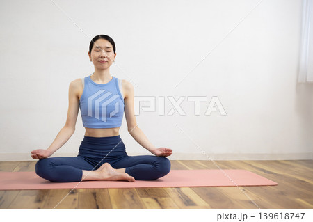 マットの上で瞑想ポーズをとる日本人のミドル女性 139618747