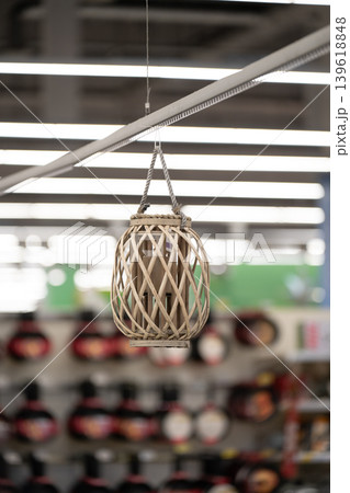 A hanging wicker lantern with a woven wooden frame. Vertical shot A hanging wicker lantern with a woven wooden frame. Vertical shot 139618848