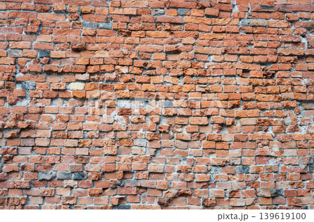Background of an ancient weathered red brick wall with irregular masonry and rough texture . Old rustic orange brickwork surface for vintage industrial design Background of an ancient weathered red brick wall with irregular masonry and rough texture . Old rustic orange brickwork surface for vintage industrial design 139619100