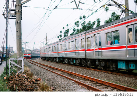 Electric commuter line train speeding across railway tracks Electric commuter line train speeding across railway tracks 139619513