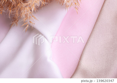Abstract background in soft colors of silk fabrics on pink pearl paper and branch Dry beige reed. Beautiful trend texture 139620347